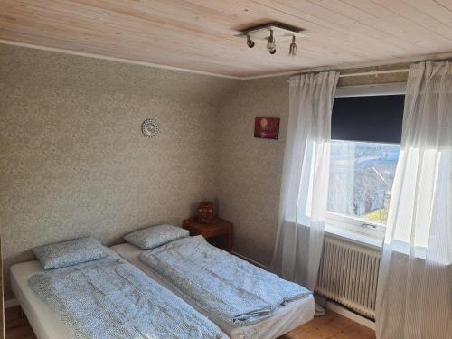 1 dormitorio con 2 camas y ventana en Liten lägenhet 2 + 2 pers en Fågelfors