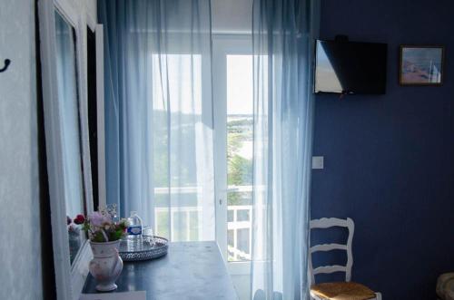 a dining room with a table and a large window at Villa les Dunes in Saint-Jean-le-Thomas