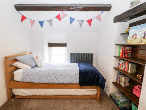 a bedroom with a bed and a book shelf at Sweetholme in Caernarfon