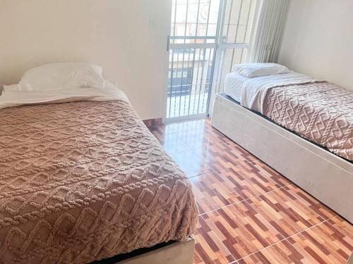 1 dormitorio con 1 cama y suelo de madera en Casa entera con patio, parrilla y cochera en Lomas de Zamora