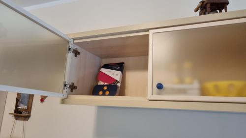 a cupboard with ajar door with a yellow chair in it at Appartamento Val di Luce Relax Cristallo in Abetone