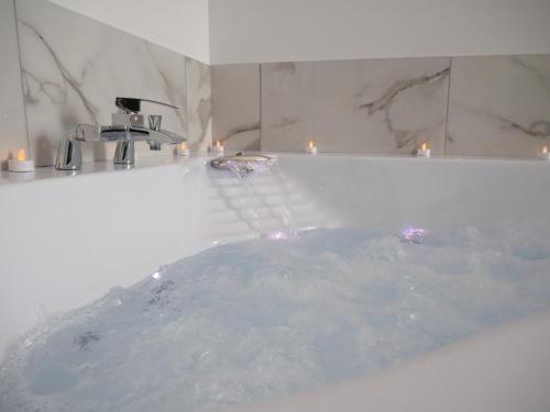 a bathroom with a tub with a water fountain at Perle d'Opale T2 FACE MER BALNÉO-SPA PARKING PRIVÉ WIFI NETFLIX HÔTEL&LOGDE 4 PERS in Berck-sur-Mer