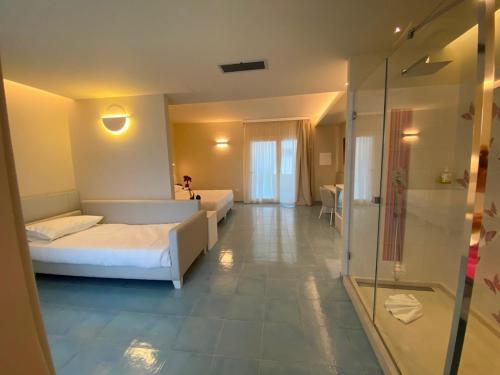 1 dormitorio con 1 cama y ducha acristalada en Hotel Village Eden, en Capo Vaticano