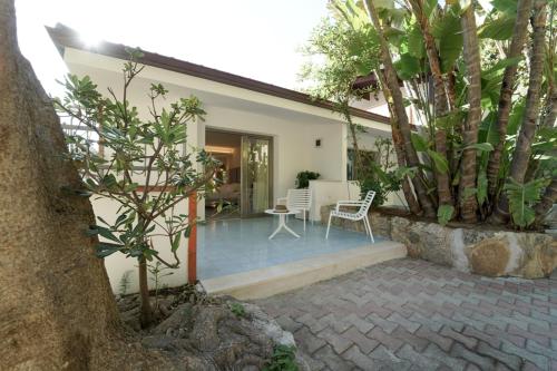 a house with a patio with a table and chairs at Hotel Village Eden in Capo Vaticano