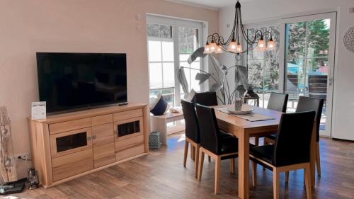 une salle à manger avec une télévision et une table avec des chaises dans l'établissement Ferienwohnung "Am Hochufer", à Göhren