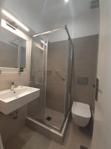 a bathroom with a shower and a sink and a toilet at Hotel 3 Adelfia in Agia Marina Aegina
