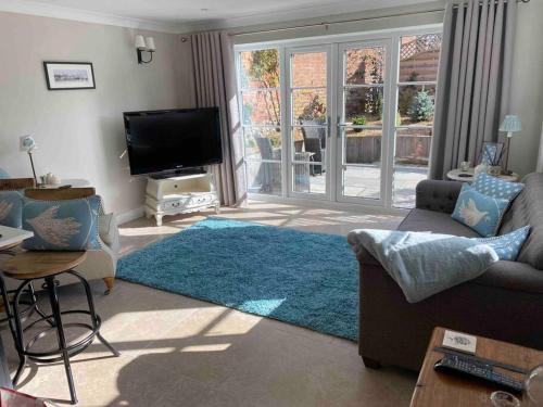 a living room with a couch and a flat screen tv at The Lodge in Birchington