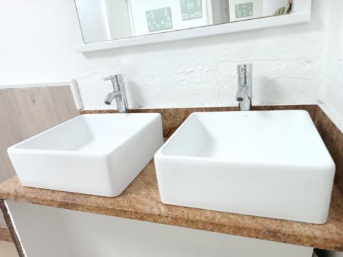 two white sinks on a counter in a bathroom at Bretema in Lugo
