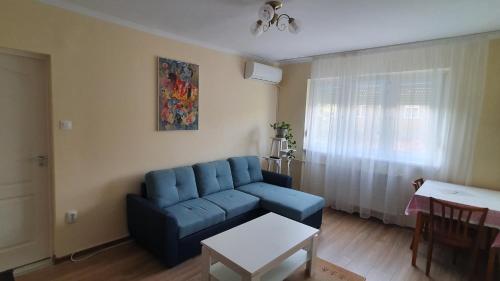 a living room with a blue couch and a table at Apartament Estera in Oradea