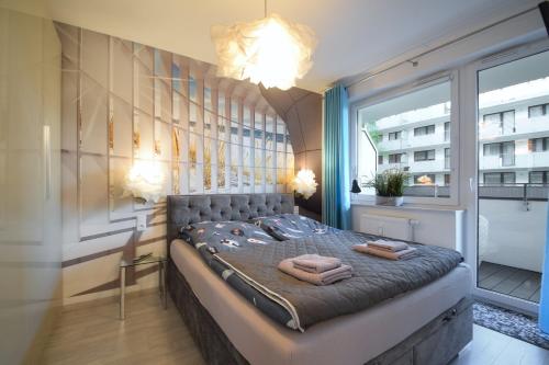 1 dormitorio con 1 cama con toallas en Apartament Dobra Energia Kołobrzeg en Kołobrzeg