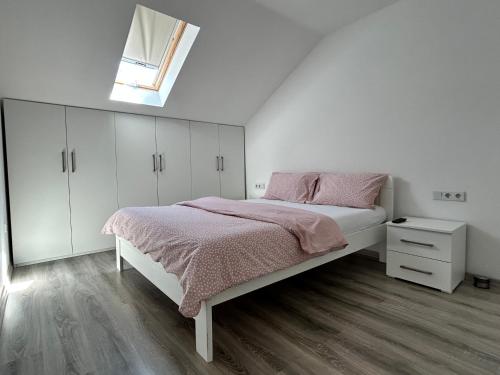 a white bedroom with a bed and a window at Ilidza Blue Nest in Sarajevo