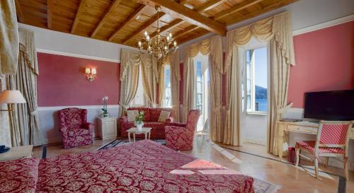 1 dormitorio con paredes rosas, 1 cama y sillas en Hotel Cannero en Cannero Riviera