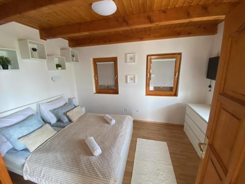sala de estar con 1 cama y 2 espejos en Paloznak Panoráma, en Paloznak