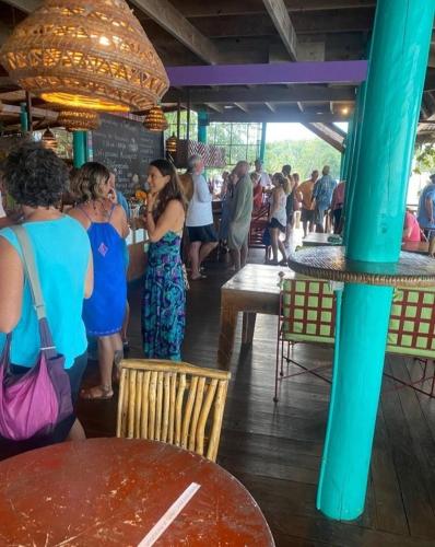 a group of people standing in a restaurant at Tortugal Boutique River Lodge in Rio Dulce