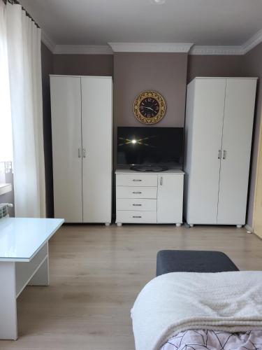 a bedroom with white cabinets and a bed and a desk at Emi Apartament in Ogrodzieniec
