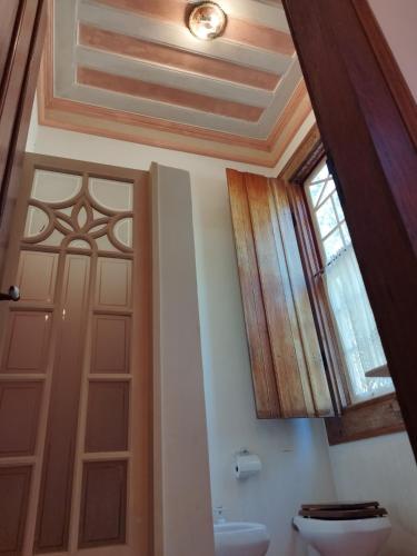 a bathroom with a door and a toilet and a window at Fazenda Cachoeira Grande in Vassouras