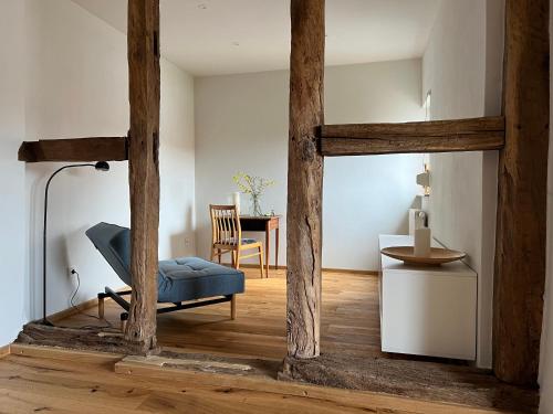 a living room with a blue chair and a table at Am Schusterberg in Schielo