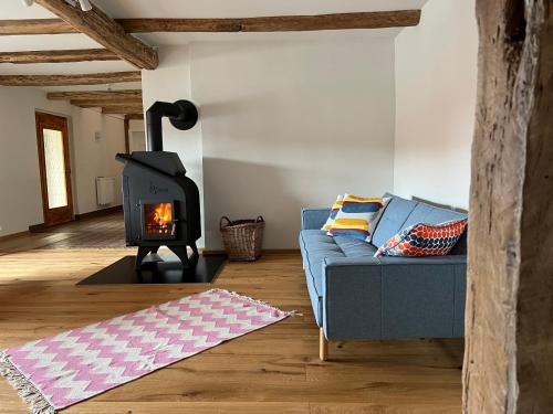 a living room with a blue couch and a stove at Am Schusterberg in Schielo