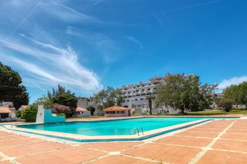 een zwembad met een gebouw op de achtergrond bij Villa Zara in Albufeira