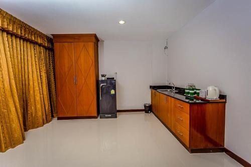 a kitchen with a sink and a refrigerator in a room at Embryo Hotel  in Pattaya Central