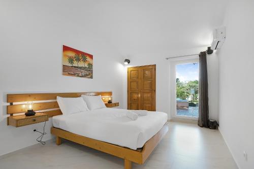 um quarto com uma grande cama branca e uma janela em Villa Zara em Albufeira