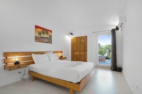 a bedroom with a large white bed and a window at Pool side Villa Zara in Albufeira