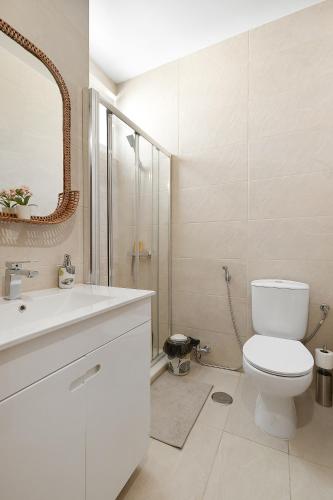 a white bathroom with a toilet and a sink at Pool side Villa Zara in Albufeira