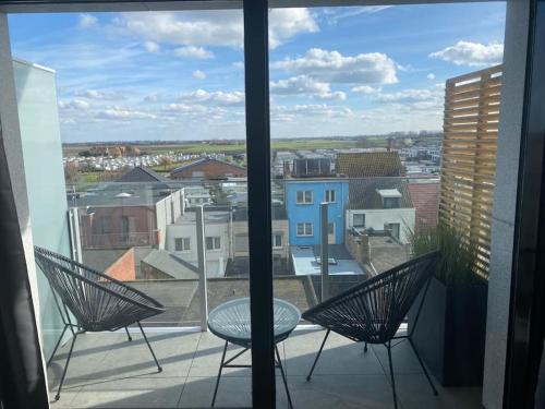 d'un balcon avec deux chaises et une table. dans l'établissement Nieuwe studio Westende Edelweiss, à Middelkerke