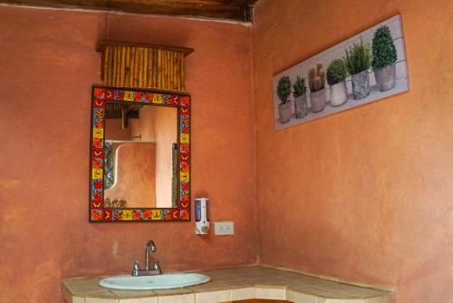 ein Bad mit einem Waschbecken und einem Spiegel in der Unterkunft Hotel Boruca Tamarindo in Tamarindo