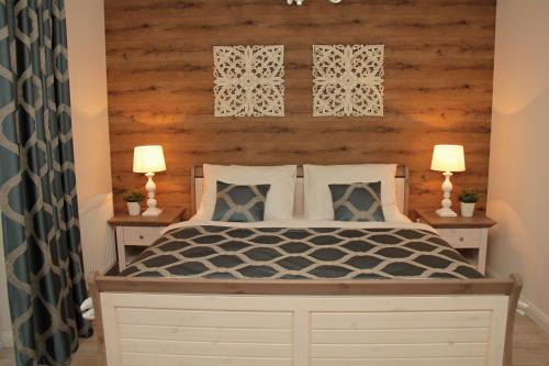 a bedroom with a wooden headboard and a bed with two lamps at Penzión a Reštaurácia Harmónia Ostratice in Malé Ostratice
