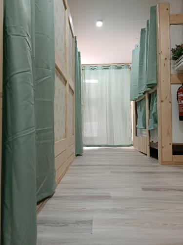 a hallway of a room with green walls and a floor at Hostel Bretema in Lugo