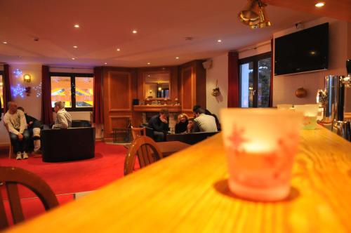 a bar with people sitting in a waiting room at Hôtel Valentin in Les Deux Alpes