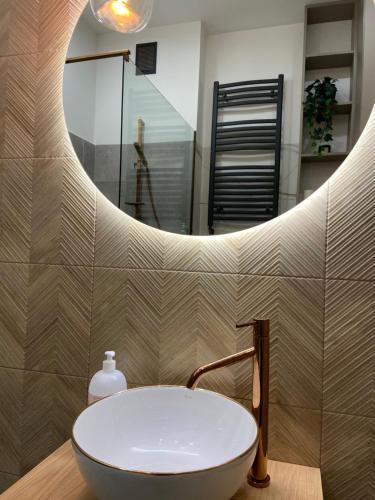 a bathroom with a white sink and a mirror at Łódź4HOME Apartament in Łódź