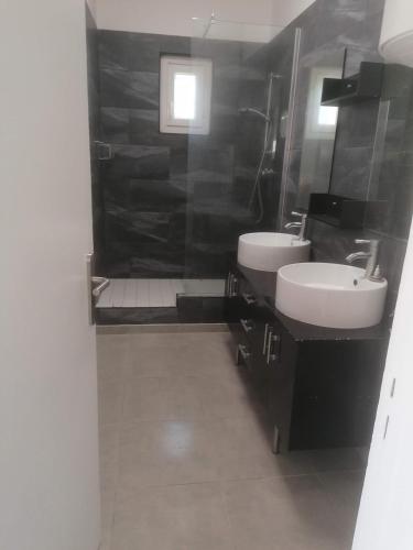 een zwart-witte badkamer met 2 wastafels en een douche bij appartement dans partie de mas en camargue in Arles