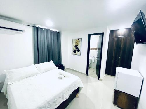 a bedroom with a white bed and a mirror at AMBAR CASA BOUTIQUE in San Andrés
