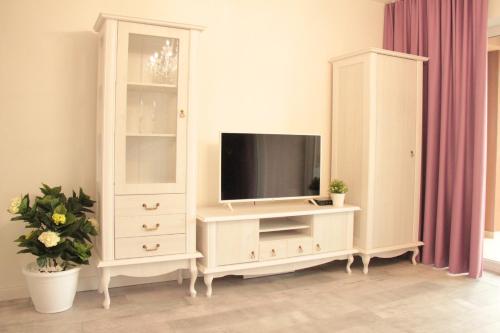 a living room with a tv and a white cabinet at Penzión a Reštaurácia Harmónia Ostratice in Malé Ostratice