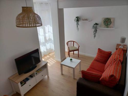 - un salon avec un canapé et une télévision dans l'établissement Piso Sol, à Laxe