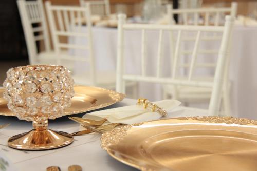 a table topped with gold plates and a diamond centerpiece at Penzión a Reštaurácia Harmónia Ostratice in Malé Ostratice