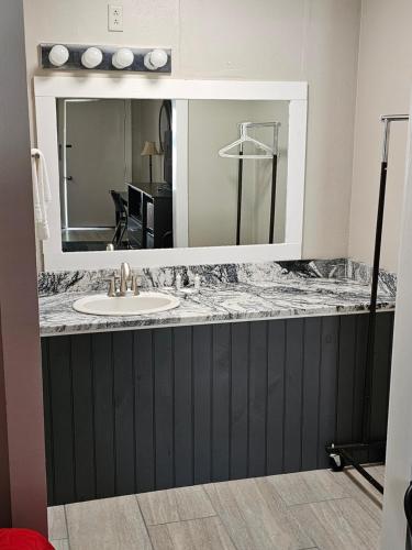 een badkamerbar met een wastafel en een spiegel bij Oak Mar Motel in Oakland