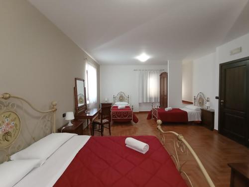 Cette chambre d'hôtel comprend deux lits et un lit rouge et blanc. dans l'établissement Città Dei Templi GuestHouse, à Agrigente