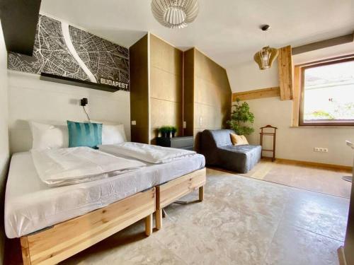 1 dormitorio con 1 cama grande y 1 silla en Charming studio shared rooftop terrace/Jacuzzi 360 view, en Budapest