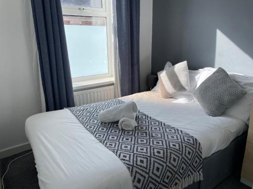 uma cama com um chapéu na frente de uma janela em Windsor 3 - Perfect Contractor Stay Free Parking 3 bedroom 4 beds Sleeps 6 em Gateshead