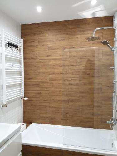 a bathroom with a shower and a white tub at Fachpol Apartments Sienkiewicza 22D in Zamość