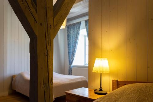 a bedroom with two beds and a lamp on a table at Skangaļu muiža in Skangaļi