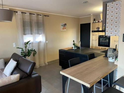 ein Wohnzimmer mit einer Couch und einem Holztisch in der Unterkunft Villa l'Amoureuse 3 in Saint-Paul-le-Jeune