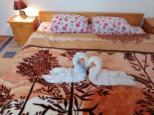 two swans are sitting on a bed at Apartment Božica in Žabljak