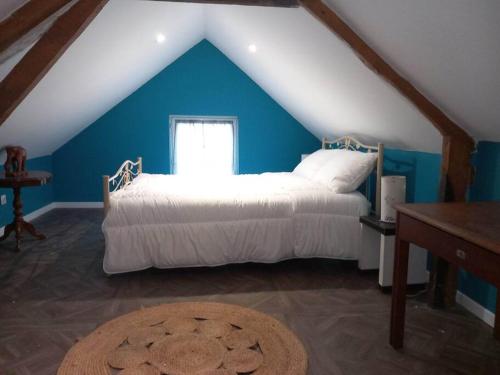 um quarto com uma cama branca e uma parede azul em gite the georgette house em Pontorson