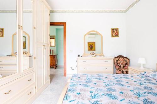 een slaapkamer met een bed, een dressoir en een spiegel bij Villa Graziosa in Trappitello