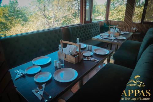 a table in a restaurant with blue plates on it at Appas Hotel in Bīr