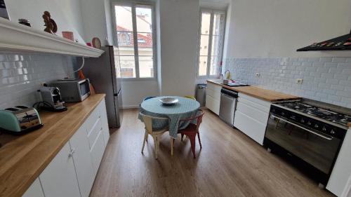 une cuisine avec une table au milieu dans l'établissement Appartement Bourgeois Cannes Palais, à Cannes
